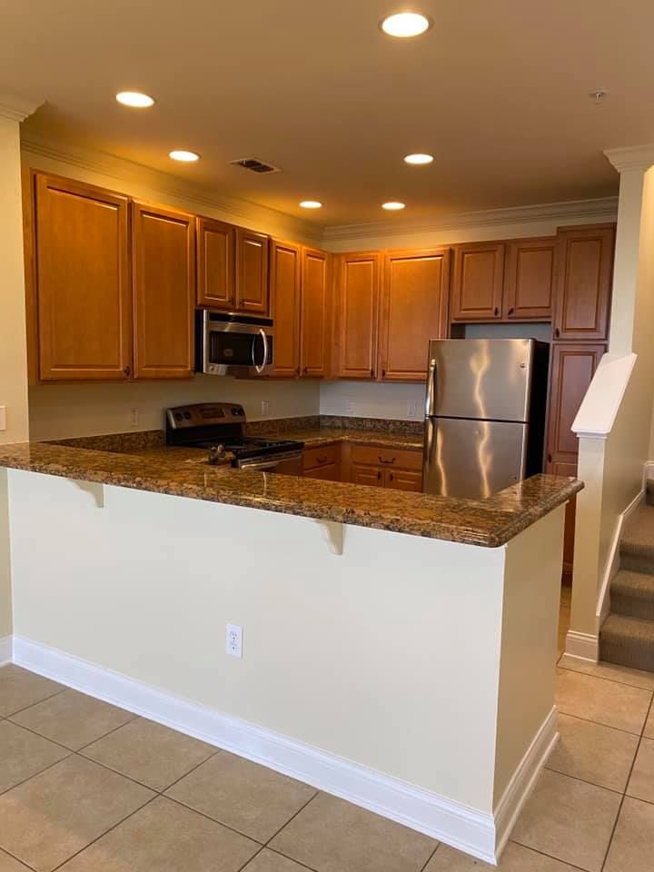 A kitchen with stainless steel appliances and granite counter tops.