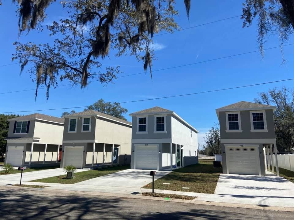 A row of houses with spanish moss hanging from the trees