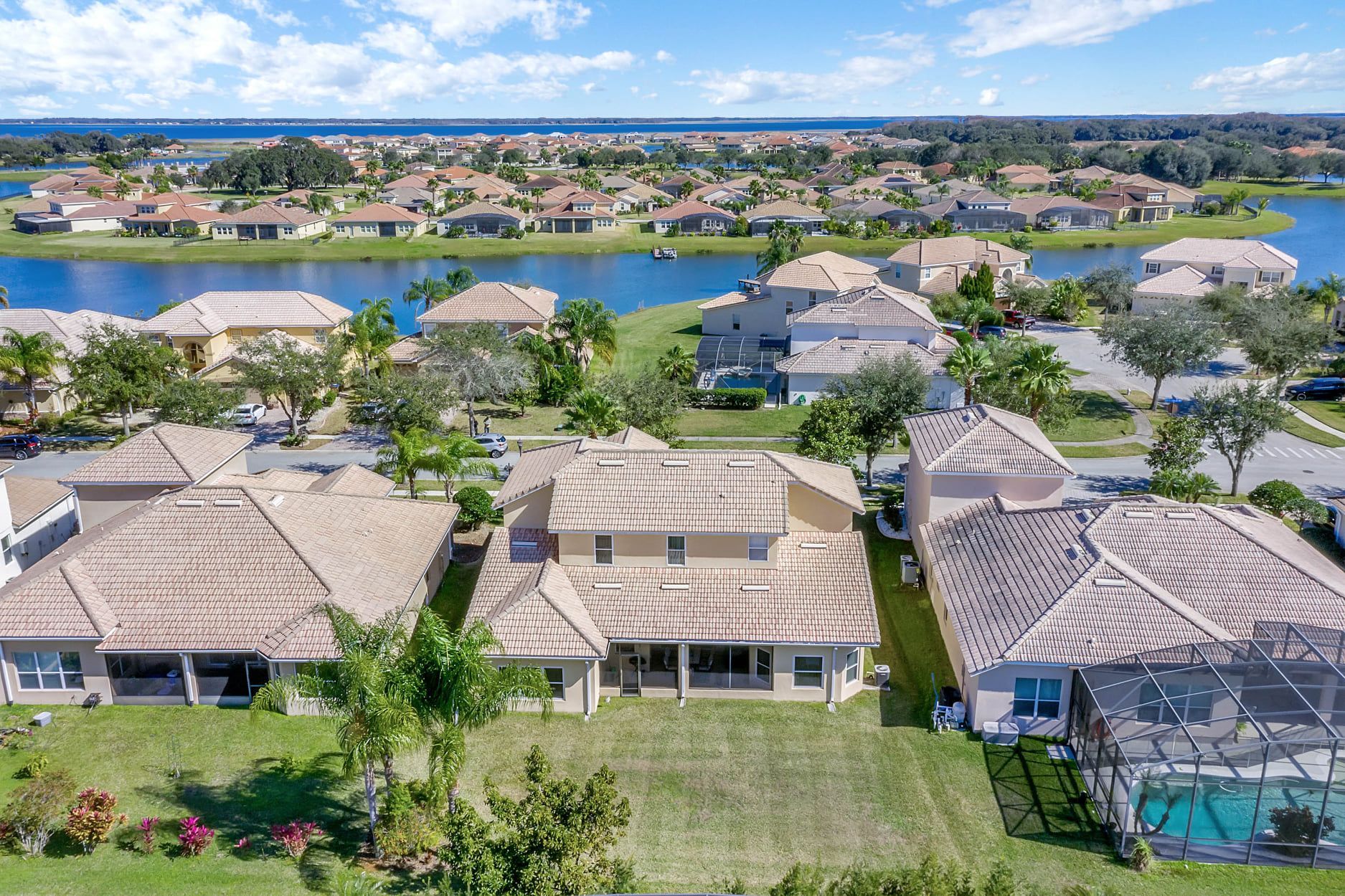 An aerial view of a residential area with houses and a lake in the background.