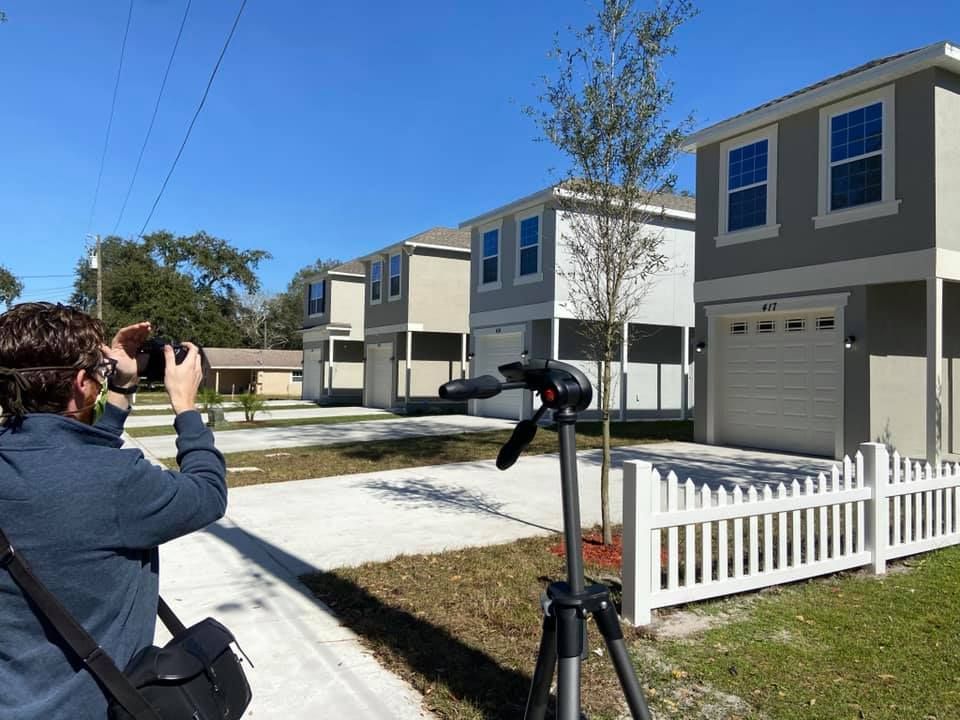 A man is taking a picture of a row of houses