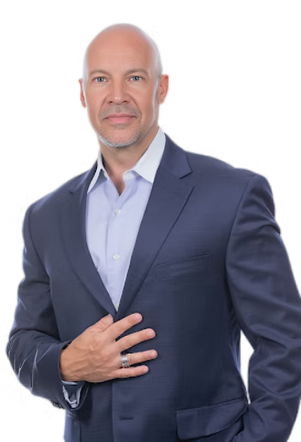 A man in a blue suit and white shirt is standing with his hands in his pockets.