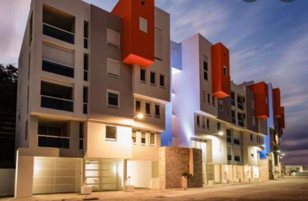 A row of apartment buildings are lit up at night