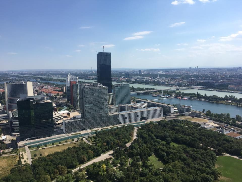 An aerial view of a city with a river and a park in the foreground.