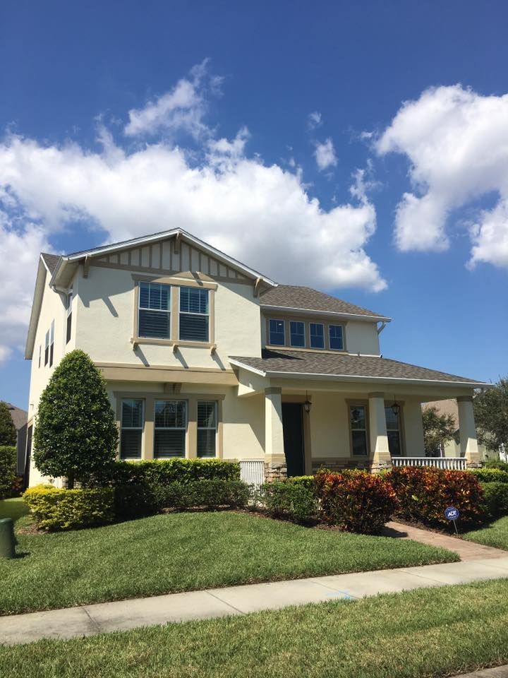 A white house with a gray roof and a lot of windows