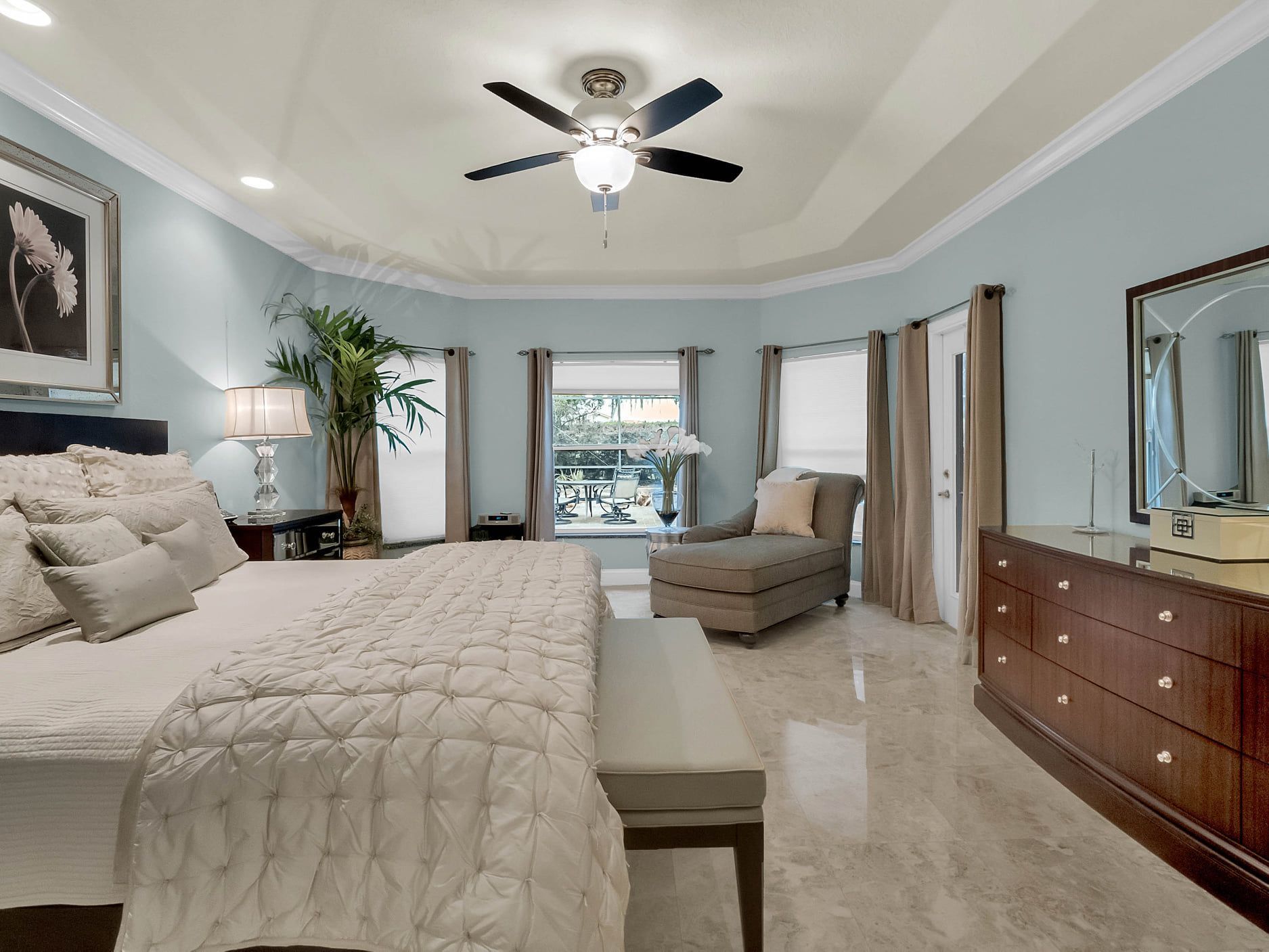 A bedroom with a large bed and a ceiling fan