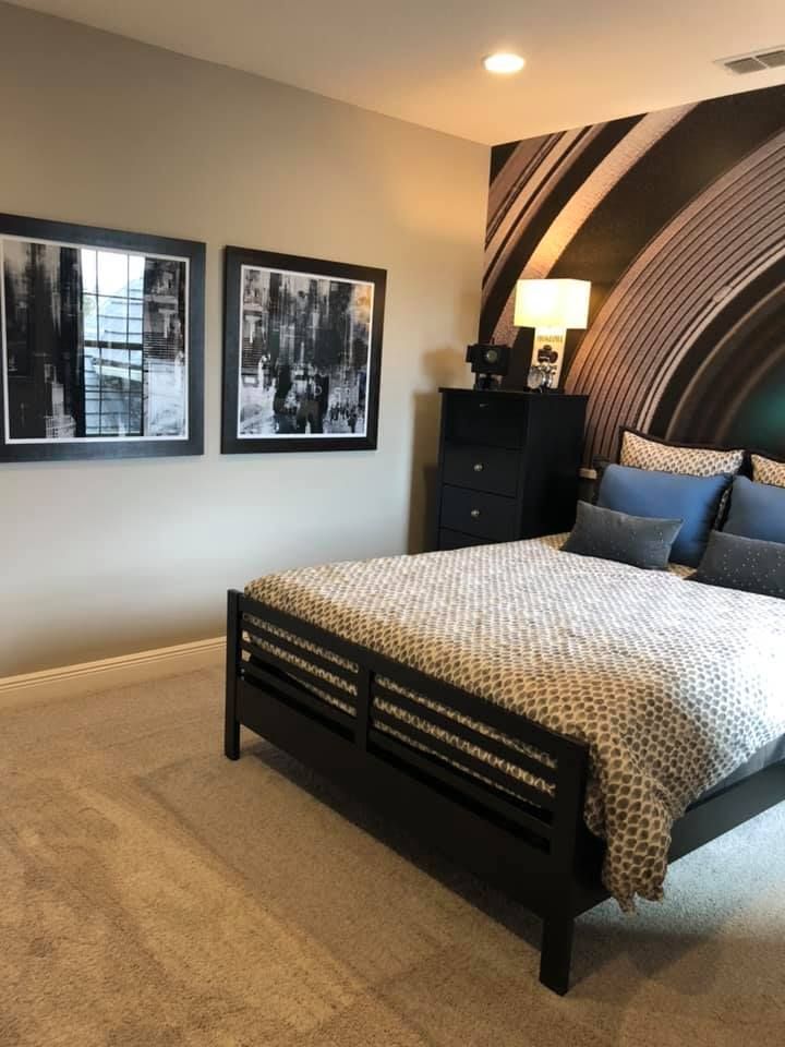 A bedroom with a bed and two pictures on the wall