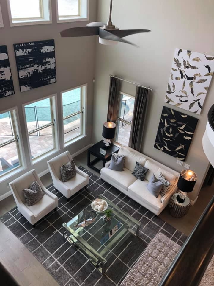An aerial view of a living room with a couch , chairs , coffee table and ceiling fan.