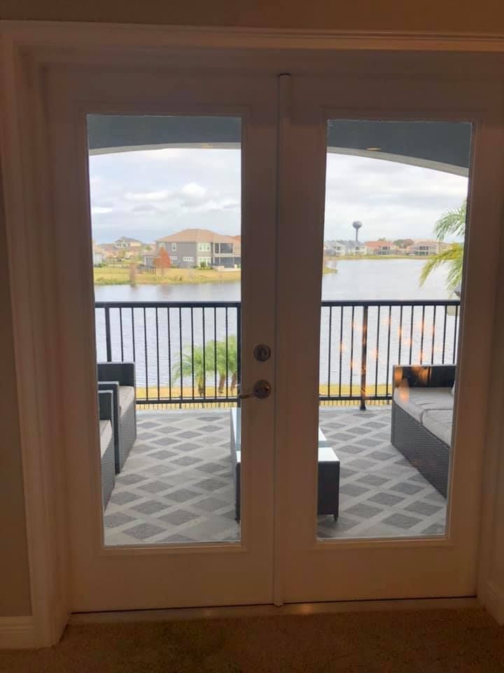 There is a balcony with a view of the water through the sliding glass doors.