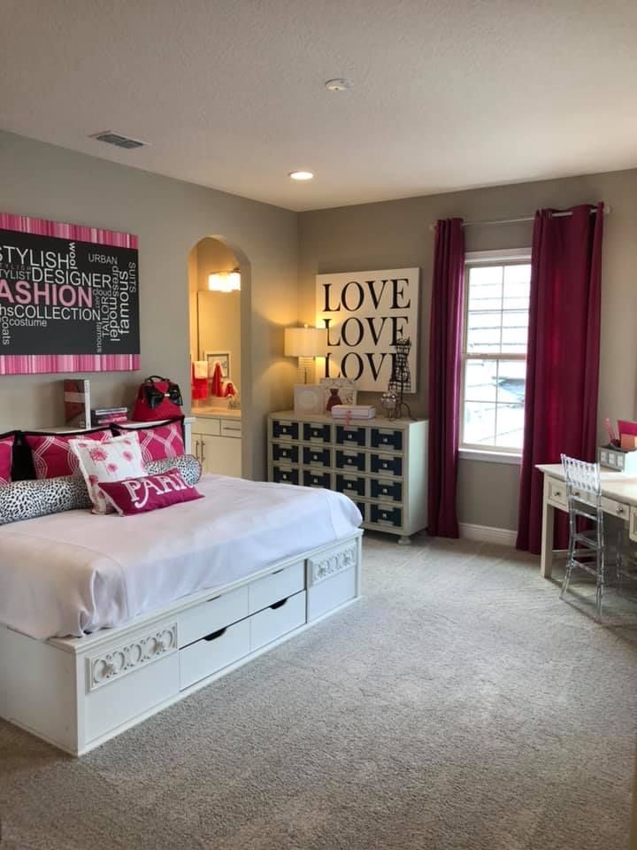 A bedroom with a bed , dresser , desk and window.