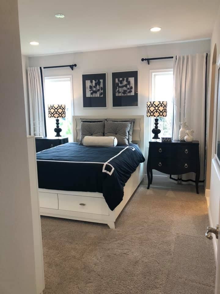 A bedroom with a large bed and two lamps