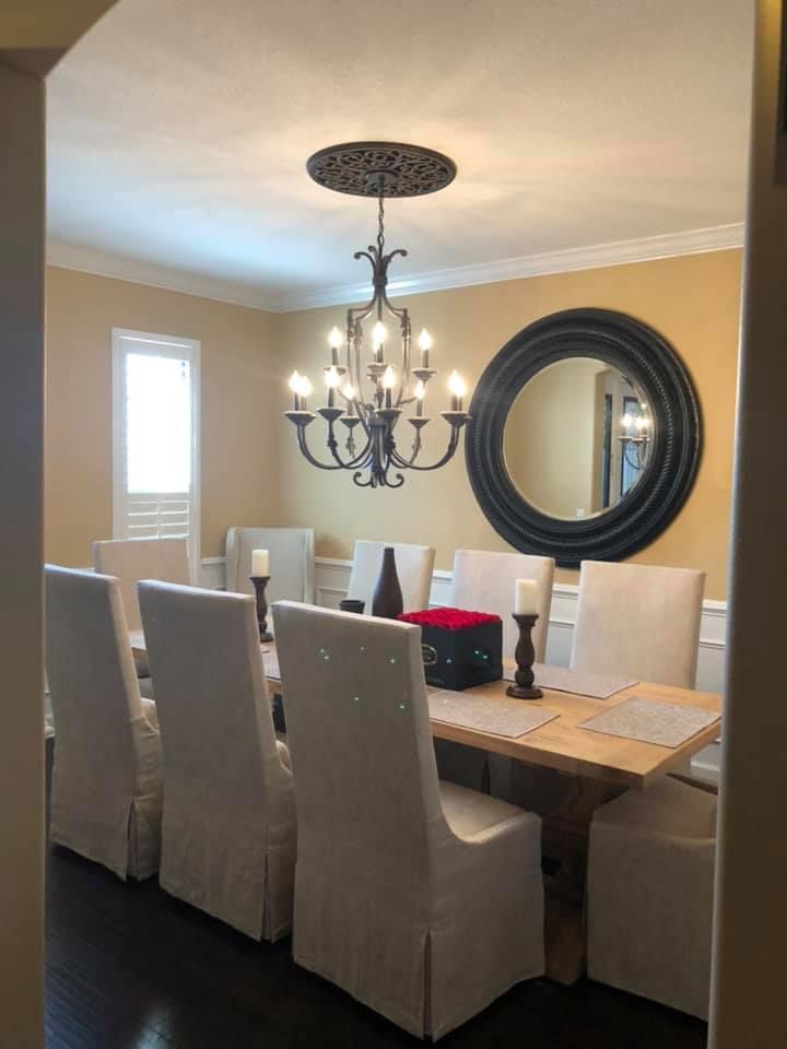 A dining room with a table and chairs and a chandelier