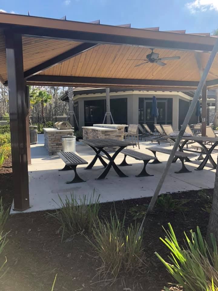 A picnic area with tables and benches under a gazebo.
