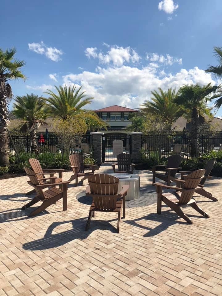 A group of wooden chairs are sitting around a fire pit.