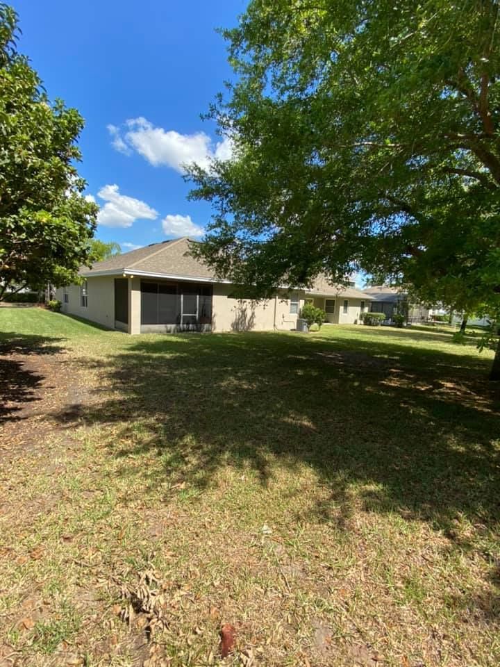A house is sitting in the middle of a lush green field surrounded by trees.