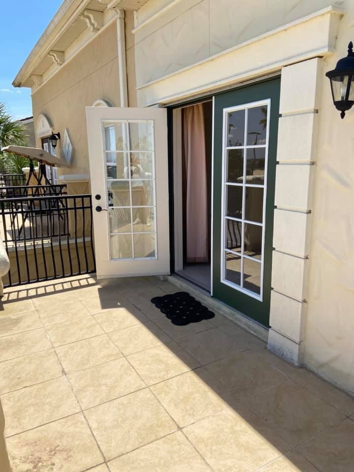 A patio with a sliding glass door leading to a room.