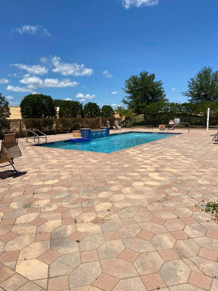 There is a large swimming pool in the middle of the patio.