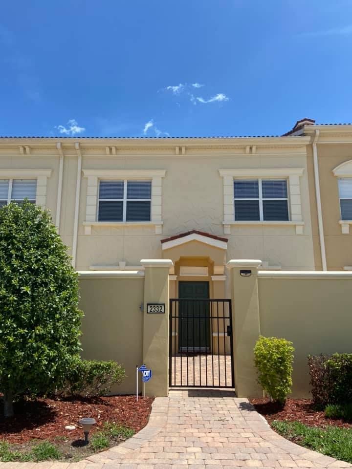 The front of a house with a brick walkway leading to it.