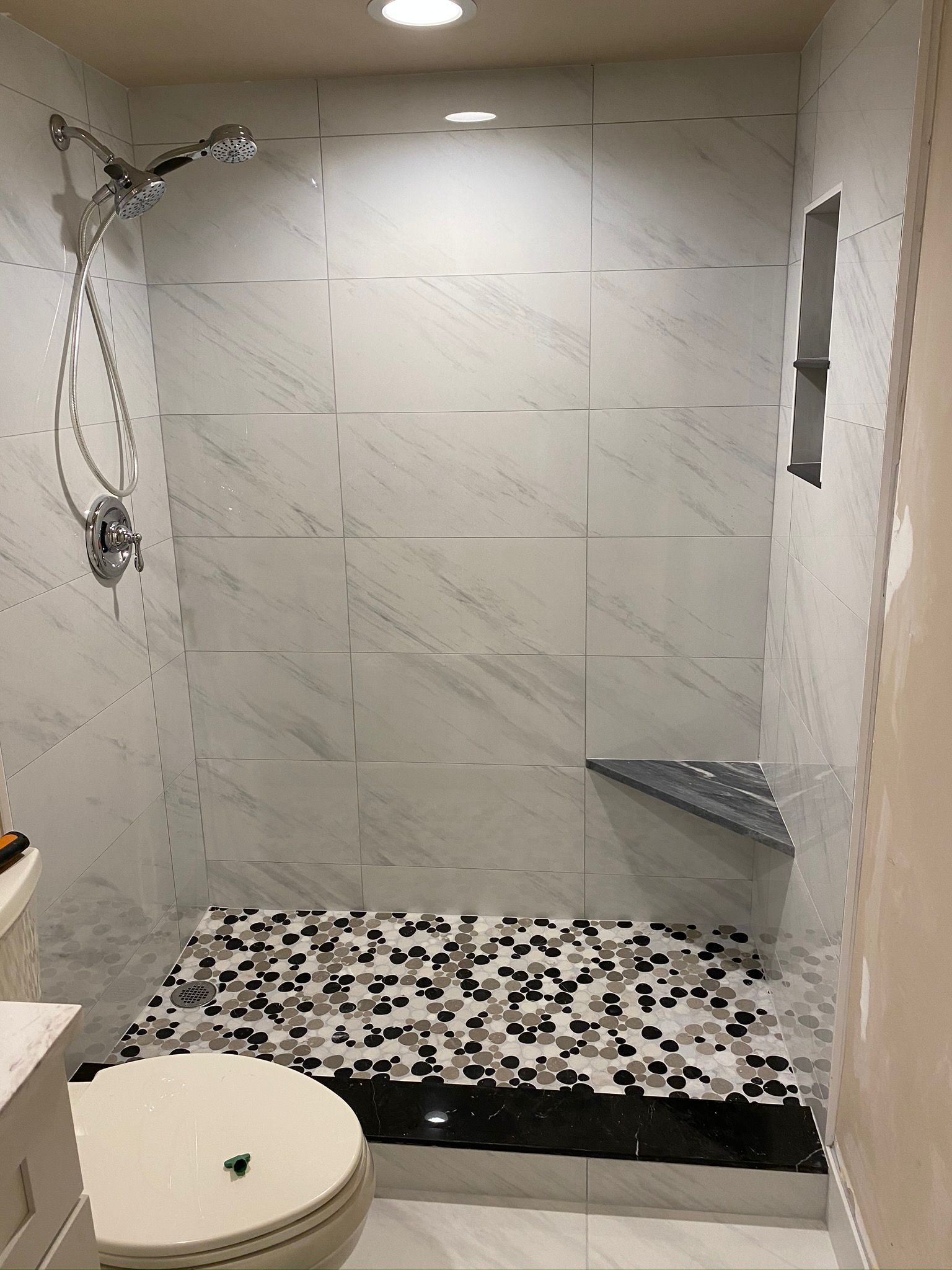 A bathroom  in Palm Beach County with a walk in shower , toilet and sink.