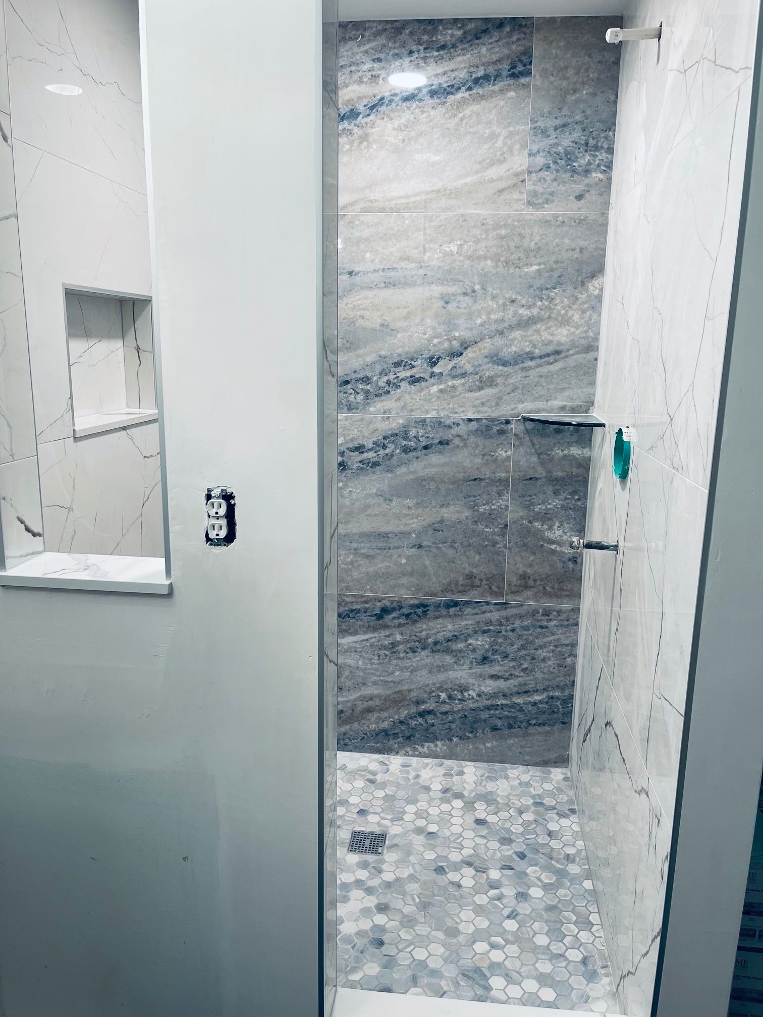 A bathroom in Palm Beach County, FL  with a walk in shower and a marble wall.
