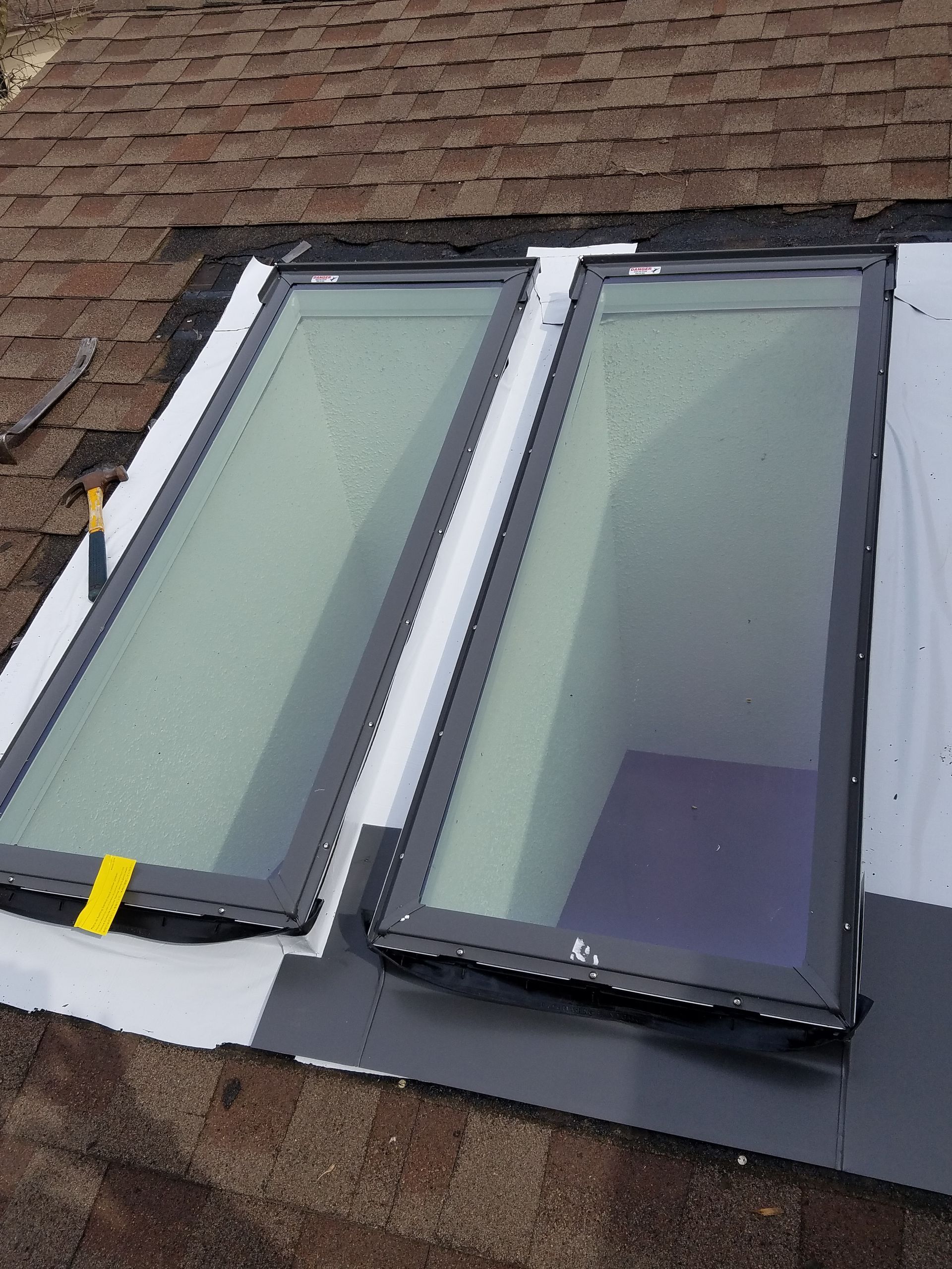 Two skylights are sitting on top of a roof.