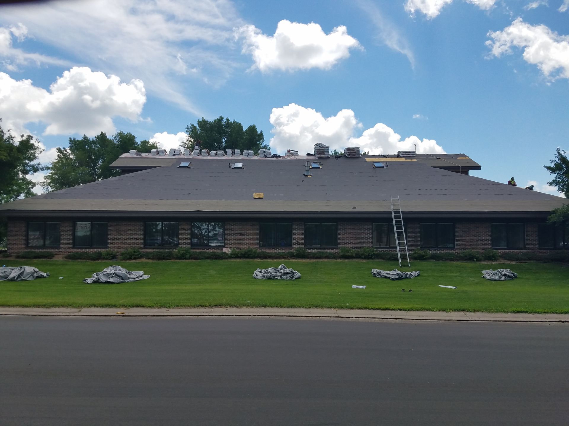 A large brick building with a roof that is being installed.