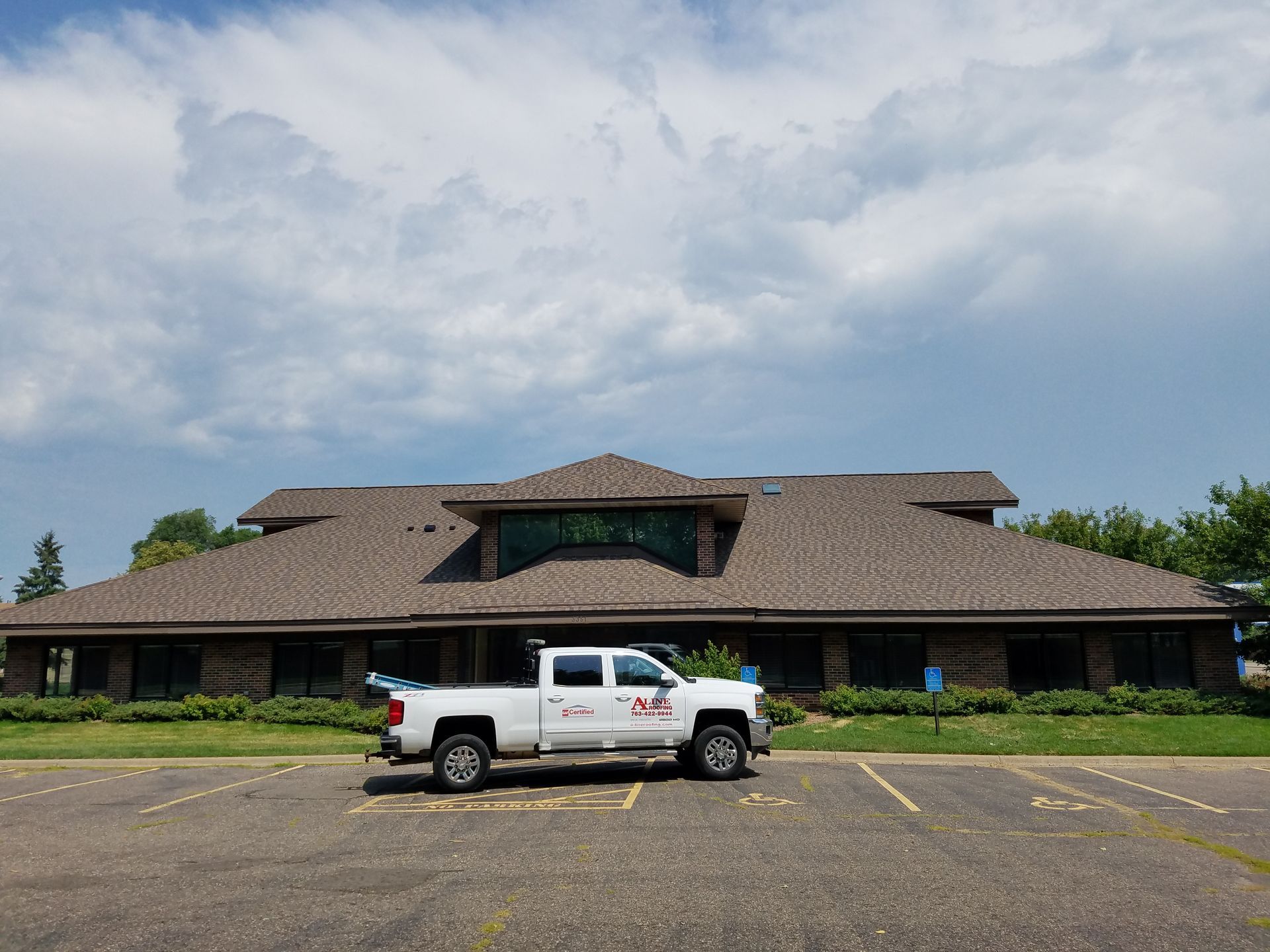 A white truck is parked in front of a large building.