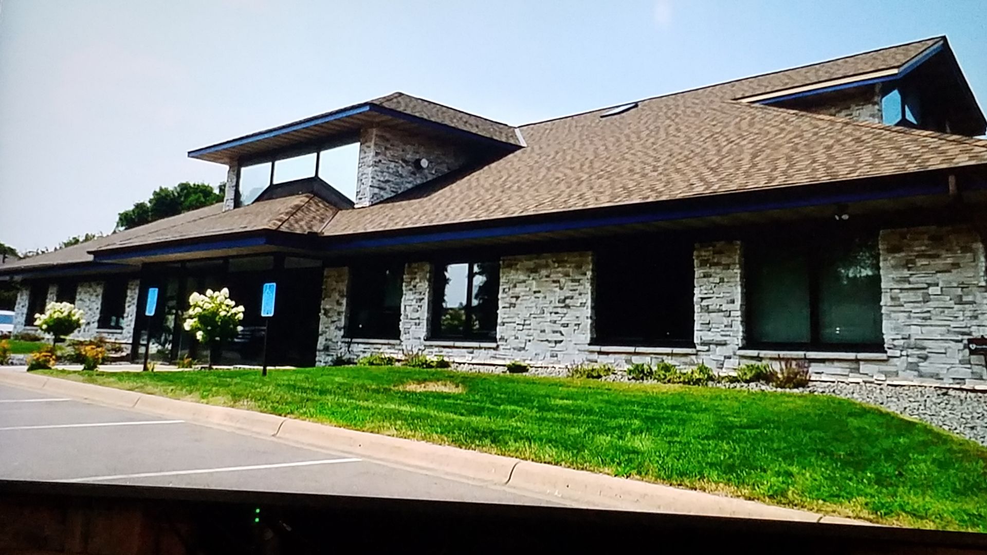 A large brick building with a brown roof and a lot of windows