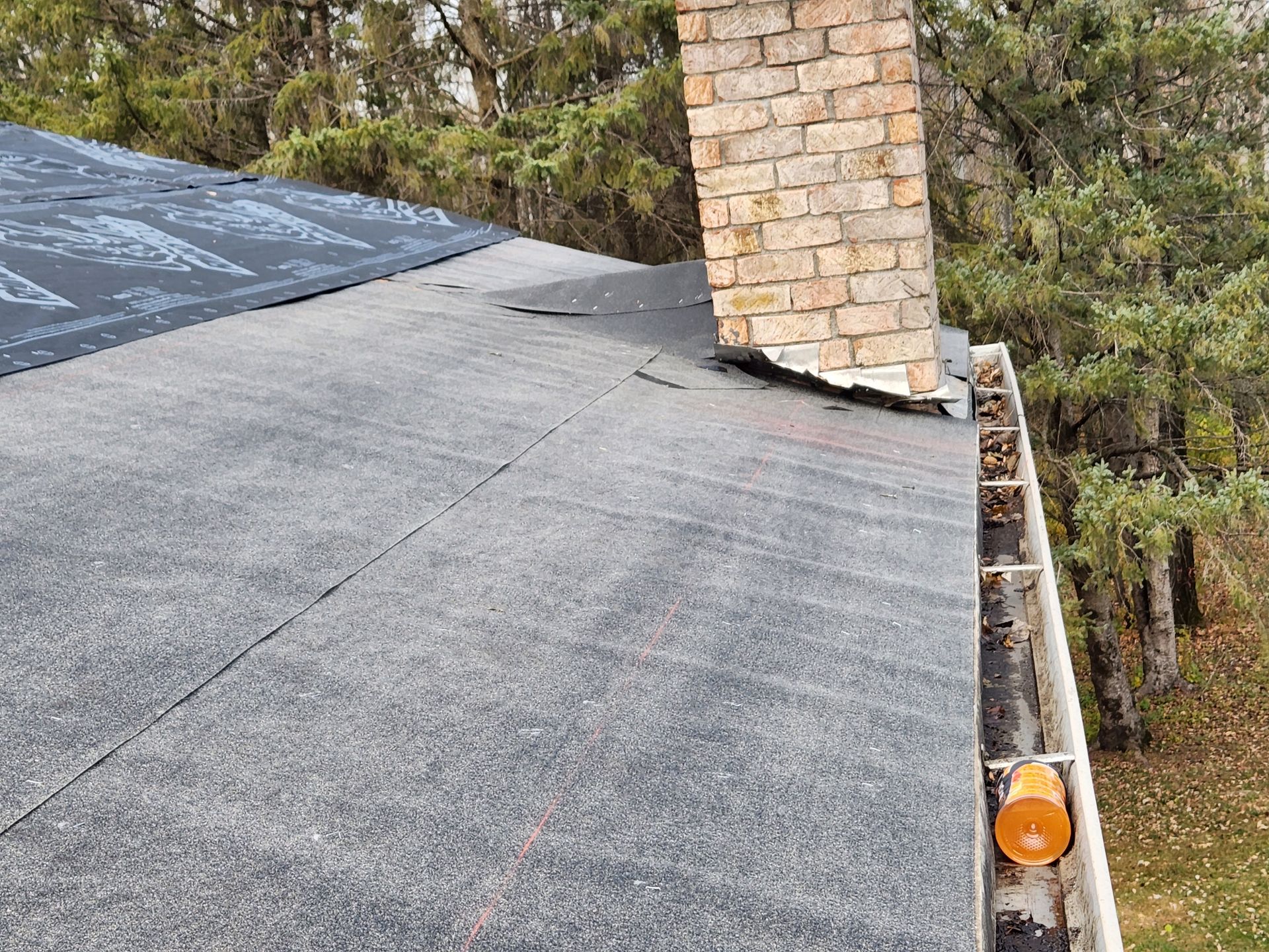 A roof with a chimney and a gutter on it.