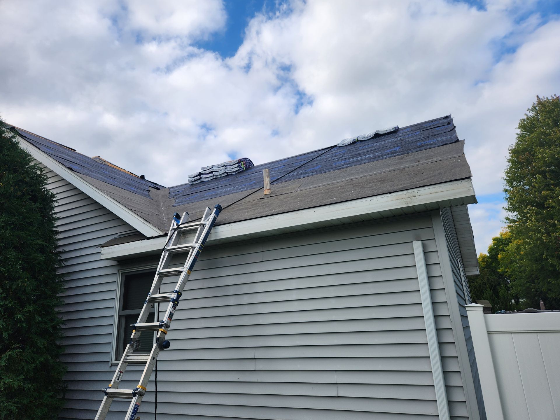 A ladder is sitting on the side of a house.