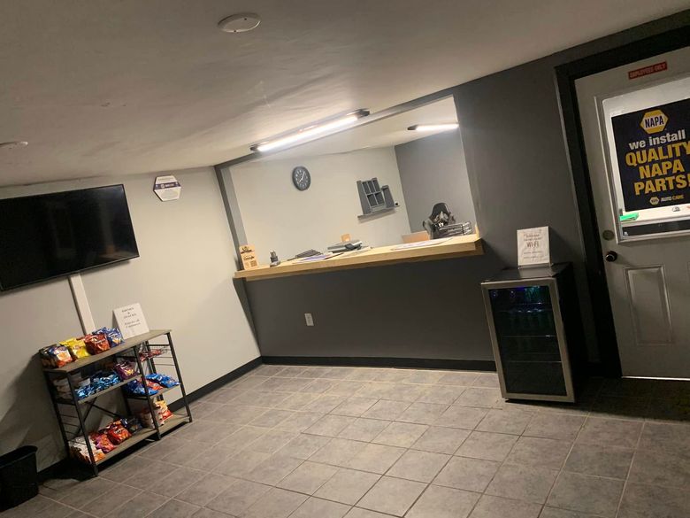A room with a counter and a refrigerator in it.