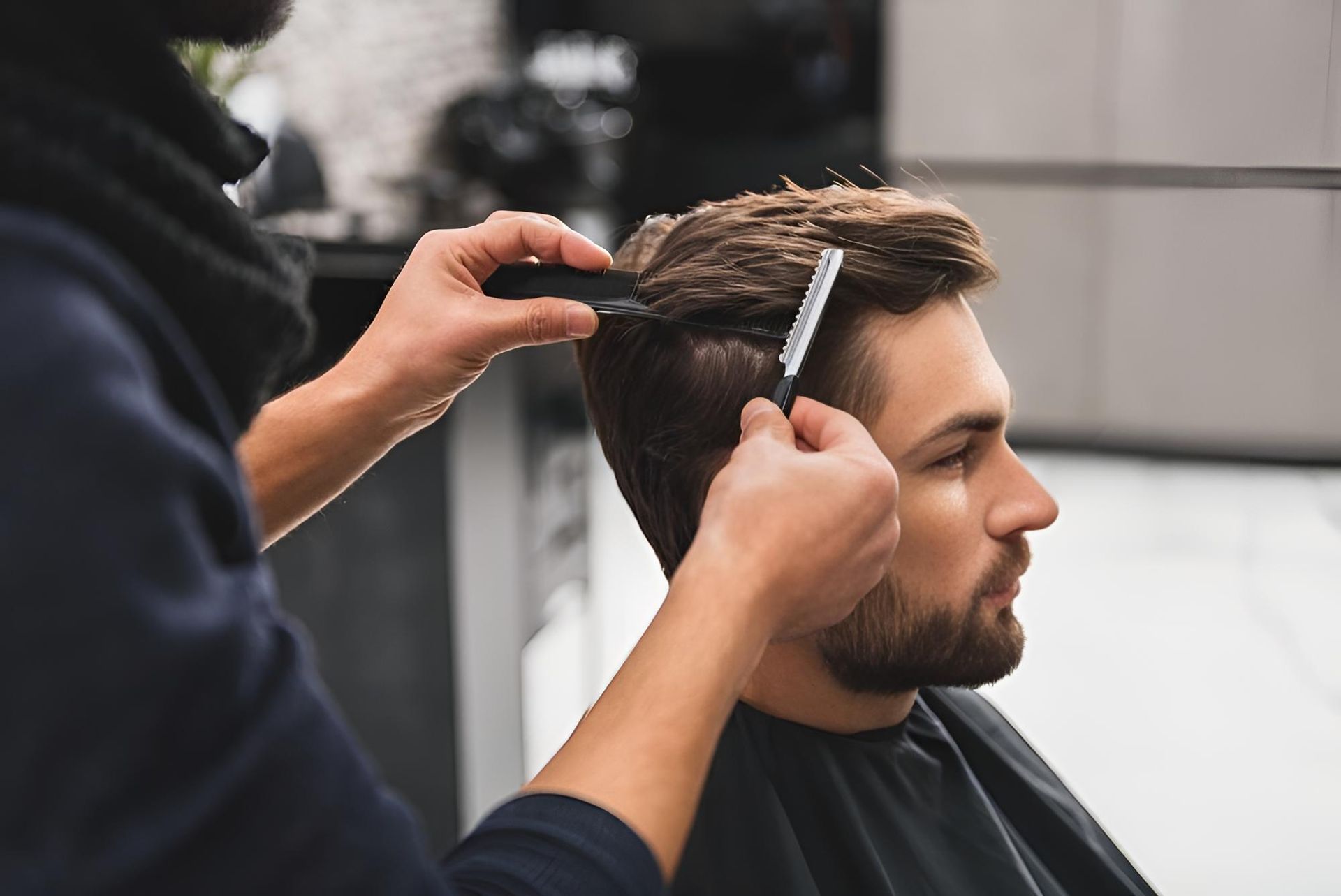 A Man is Getting His Hair Cut at a Barber Shop — Dudes n Dolls Hair Lounge In Warners Bay, NSW