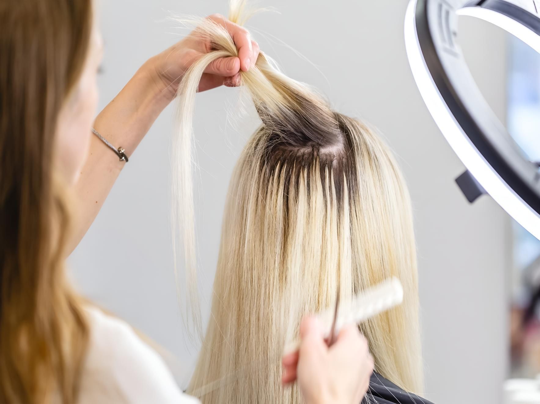 A Woman is Getting Her Hair Done by a Hairdresser in a Salon — Dudes n Dolls Hair Lounge In Warners Bay, NSW