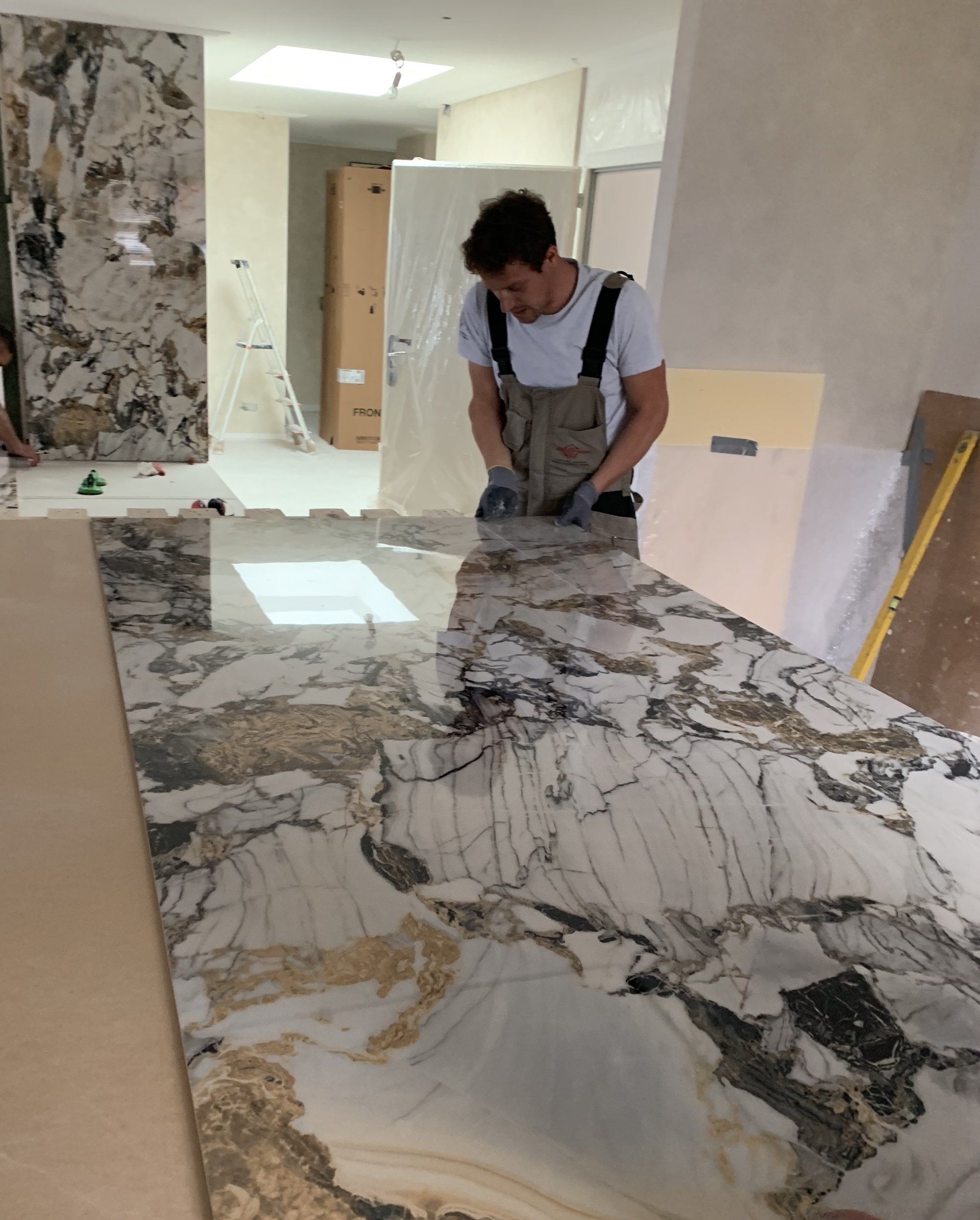 Ouvrier posant une plaque de marbre pour plan de travail de cuisine