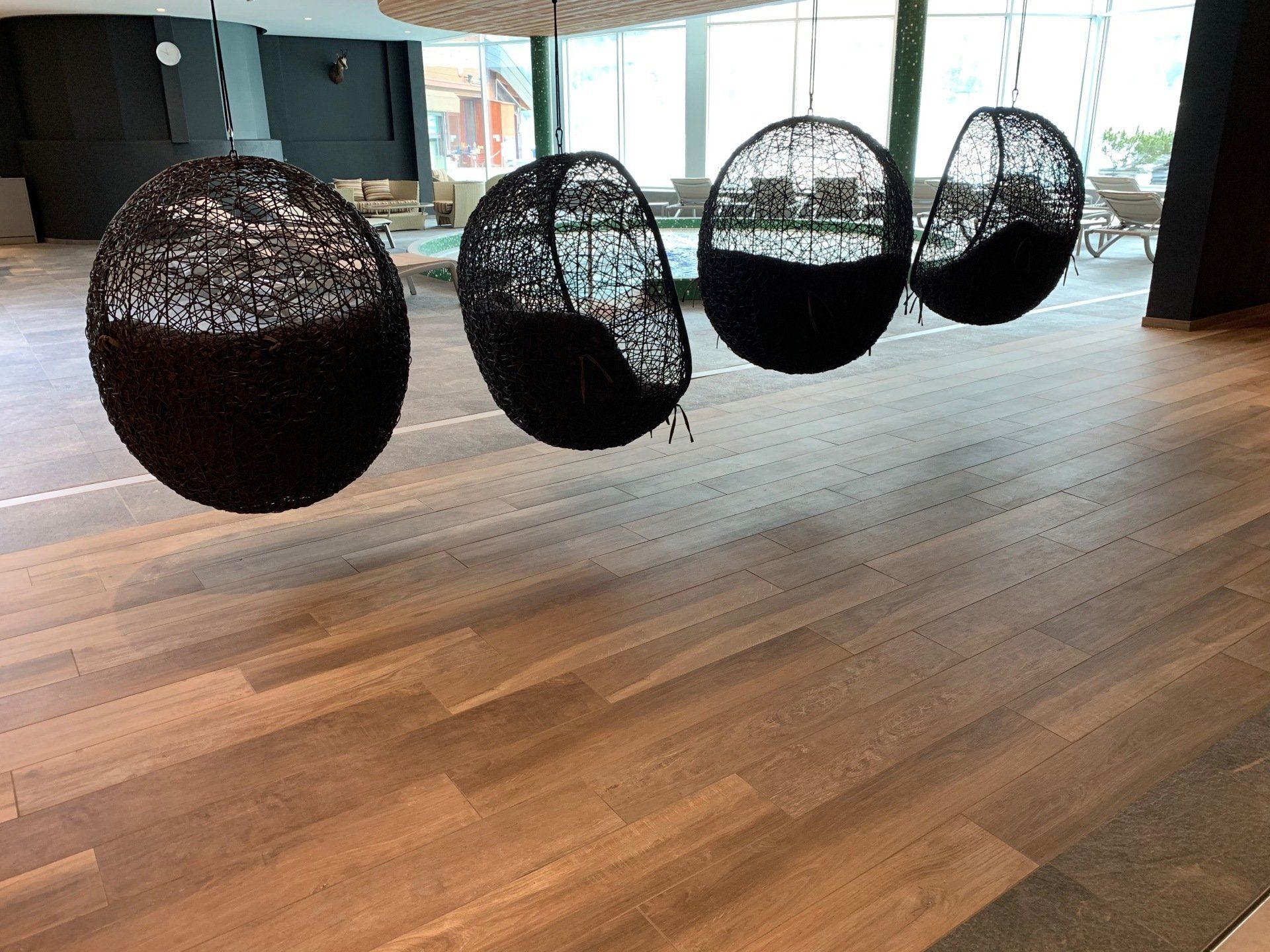 salle lounge avec quatre chaises suspendues