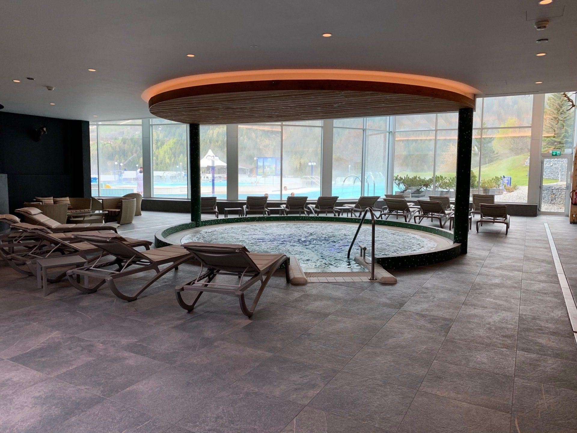 bassin rond intérieur cerné de chaises longues