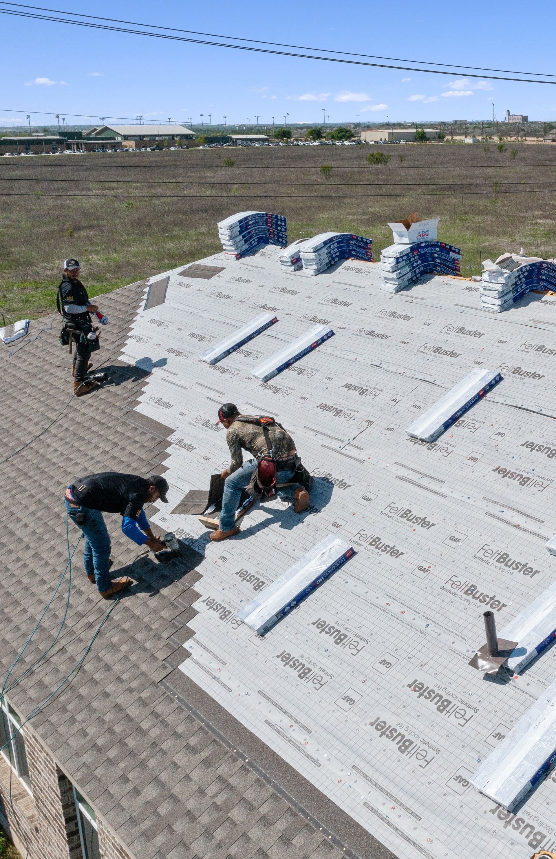 Two men are working on the roof of a house.