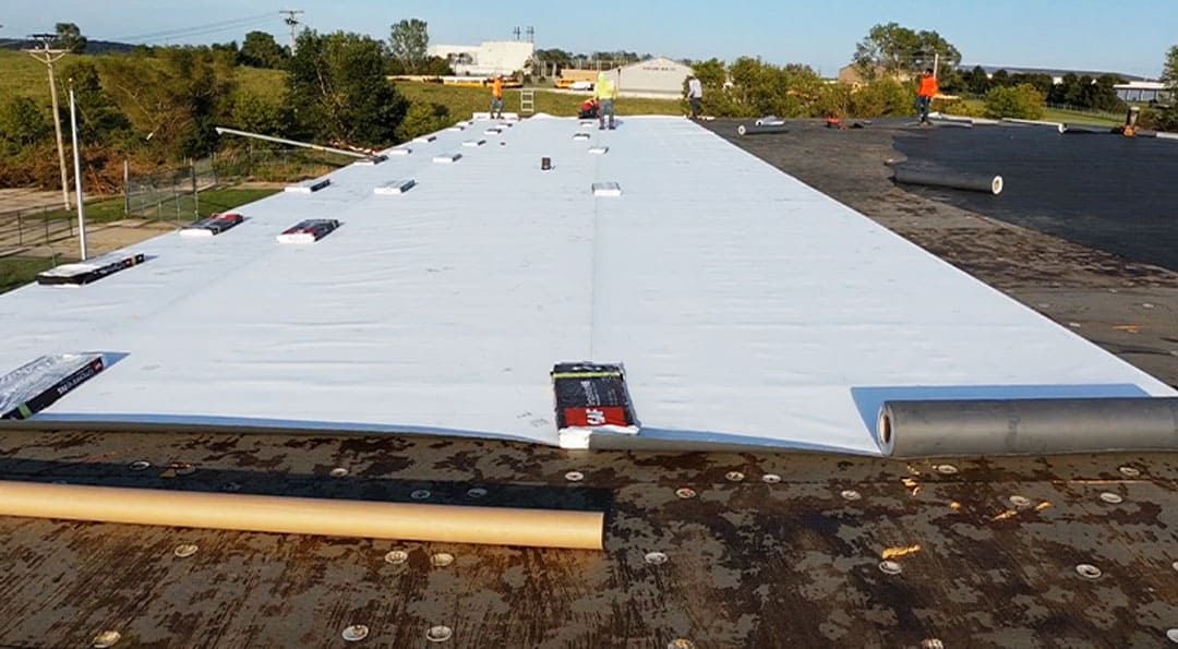 A large white roof is being installed on a building.