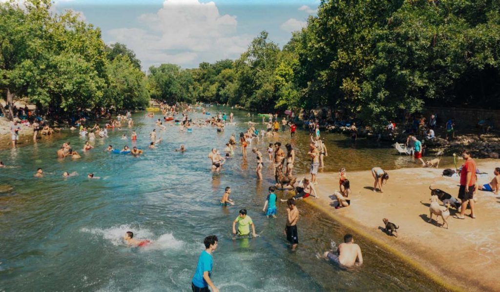 A group of people are swimming in a river.
