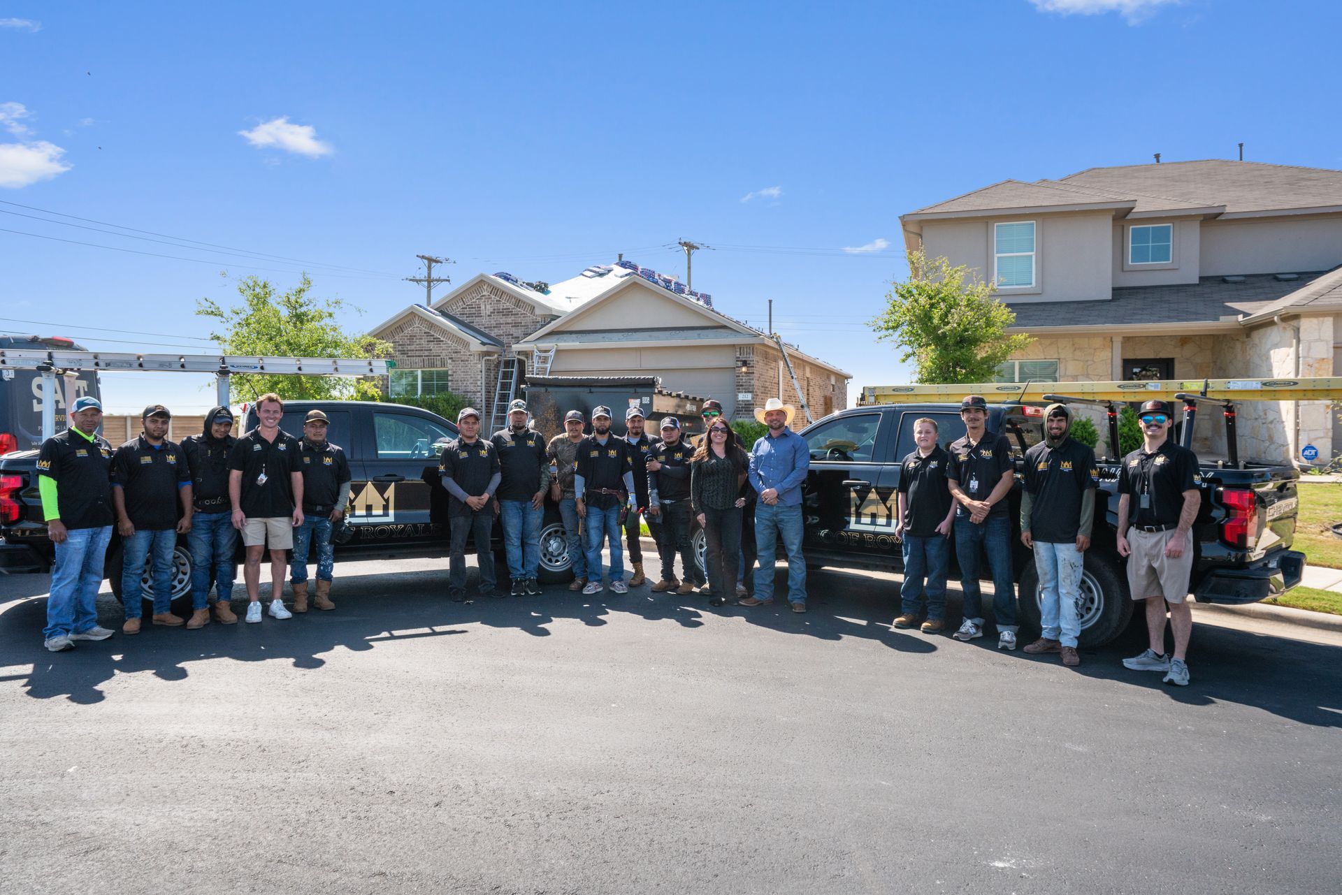 A group of construction workers are standing on top of a wooden roof.