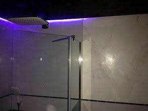 Weiße Wand mit Marmorimitation und lila Hintergrundbeleuchtung