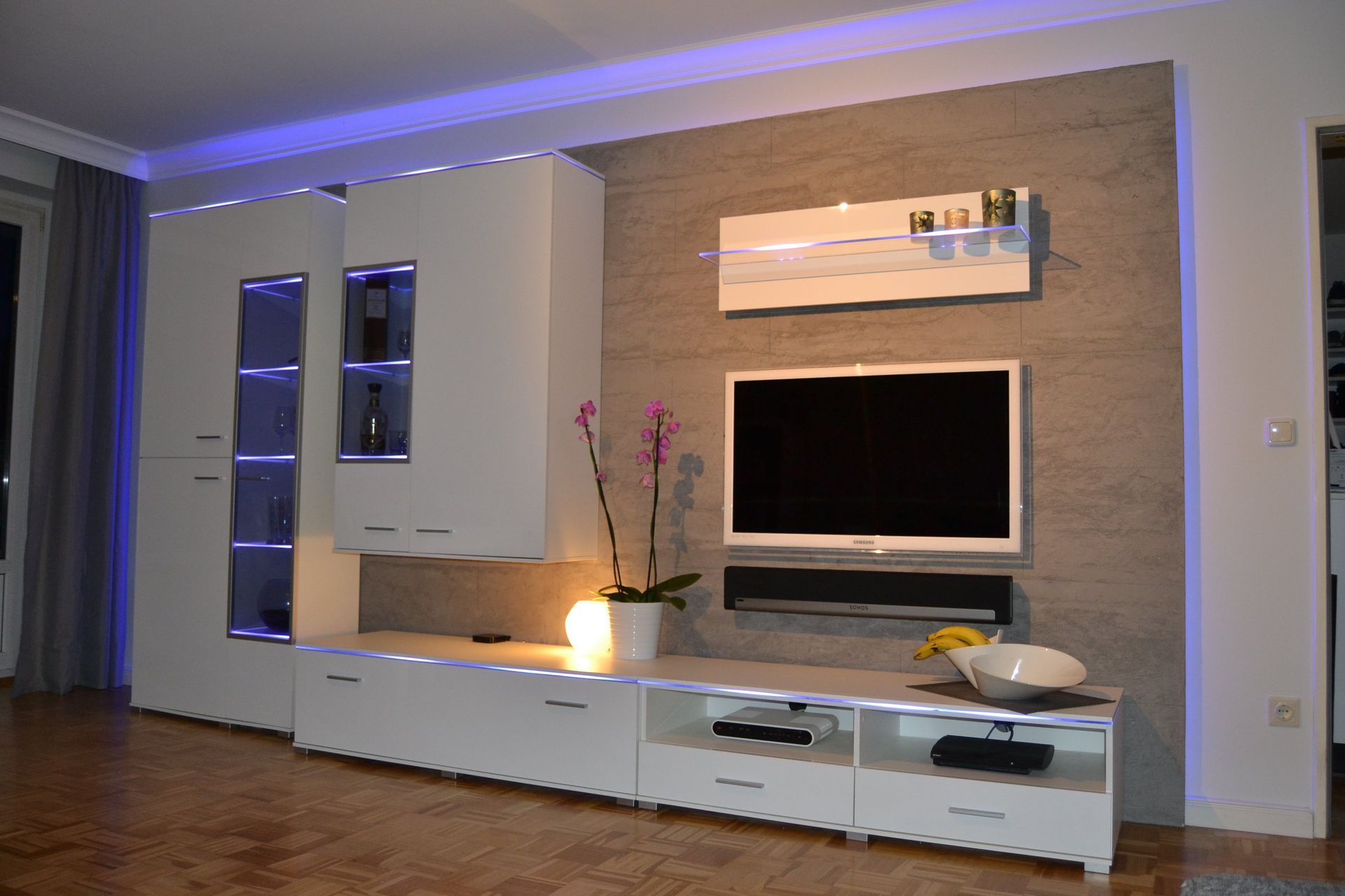 Fernseher und Wohnwand vor authentischer Steinoberfläche