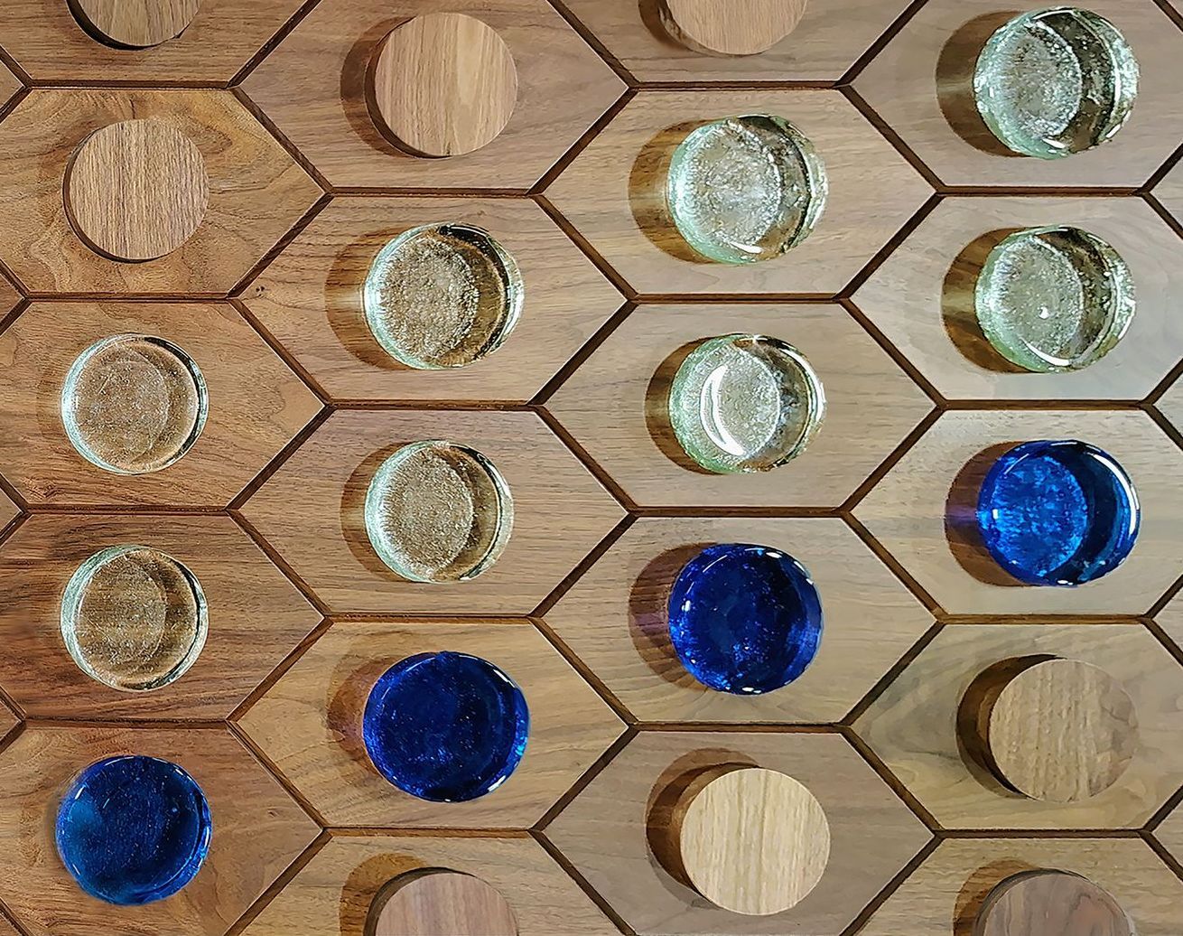 A wooden board with blue and clear marbles on it