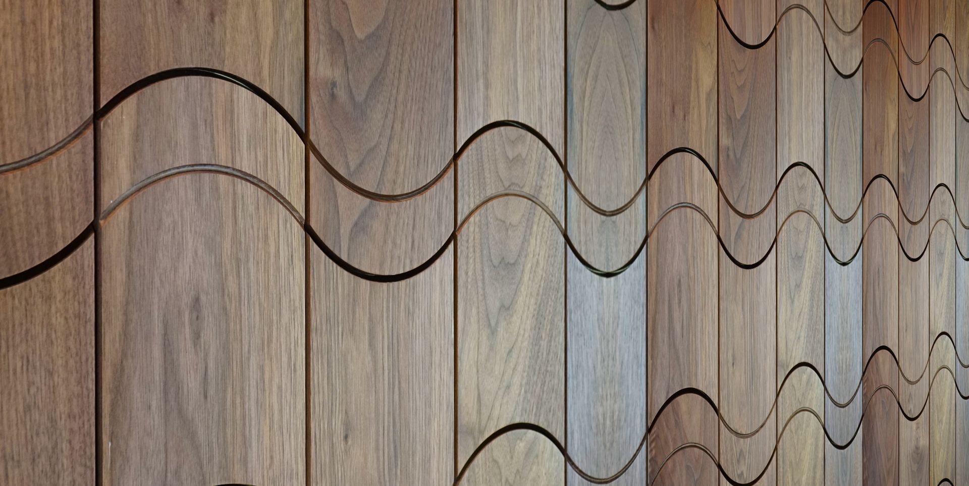A close up of a wooden wall with waves carved into it.