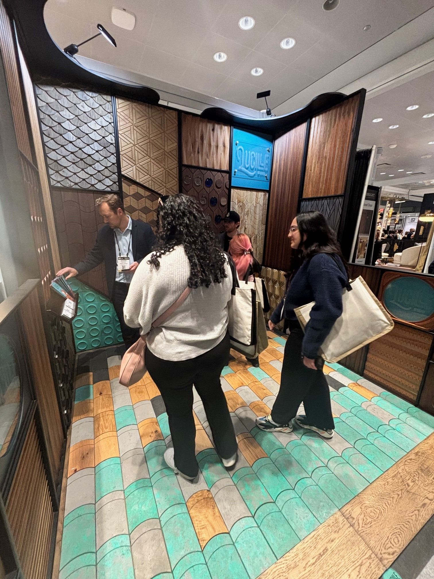 People looking at tile samples in a display booth at a trade show.