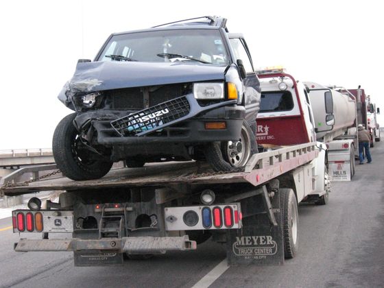 Flatbed towing a wrecked suv