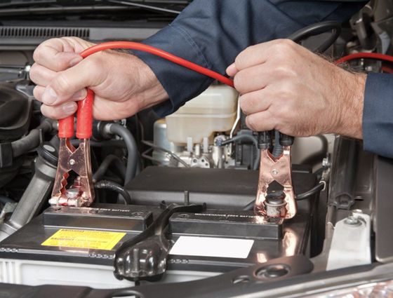 guy placing jumper cables on a dead battery
