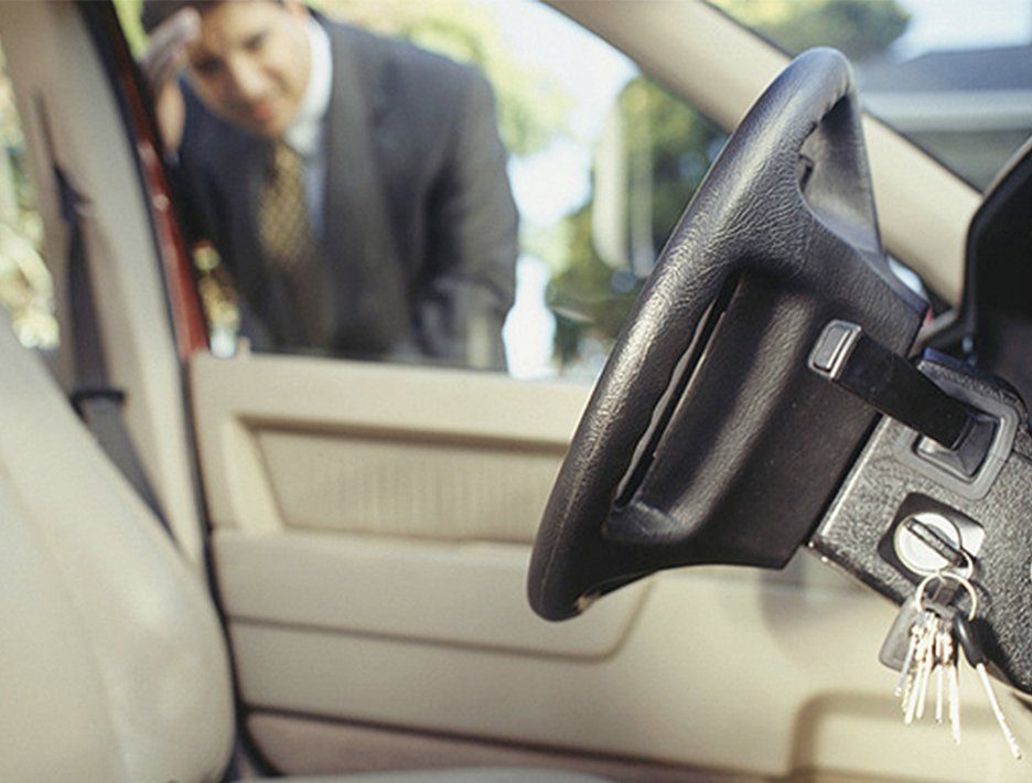 Gentleman looking into the window of his car looking for his keys