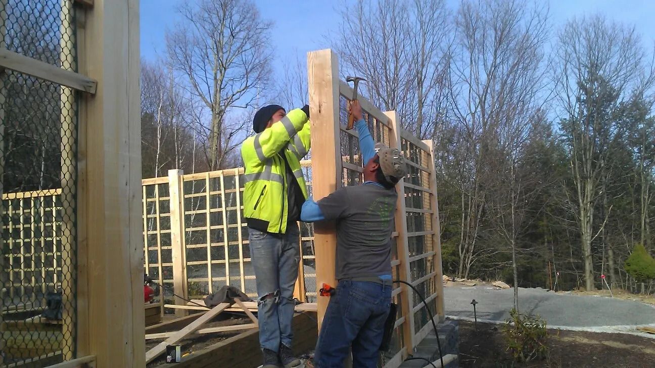 Men building a fence — Newburgh, NY — Benjamin & Sons Landscaping