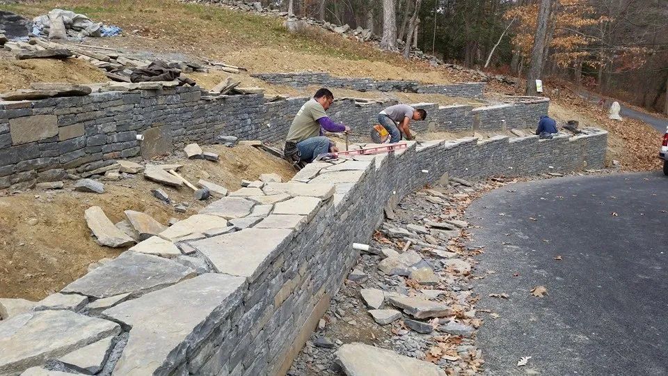 Men working on a stone wall — Newburgh, NY — Benjamin & Sons Landscaping