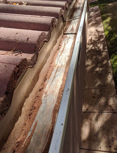 A close up of a gutter on a tiled roof